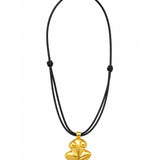 A gold pendant necklace featuring a stylized frog charm hanging from a black double-strand cord, shown against a plain white background.