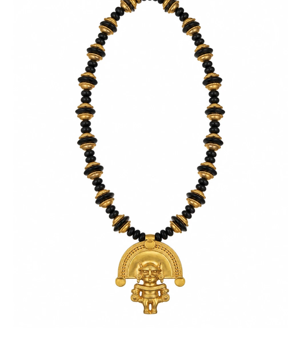 A gold and black beaded necklace featuring a detailed gold pendant with a stylized figure and semicircular design, set against a plain white background.