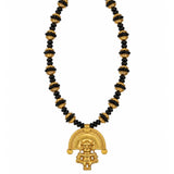 A gold and black beaded necklace featuring a detailed gold pendant with a stylized figure and semicircular design, set against a plain white background.