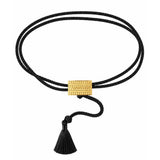 A double-strand black cord bracelet with a textured gold rectangular clasp and a black tassel, shown on a plain white background.