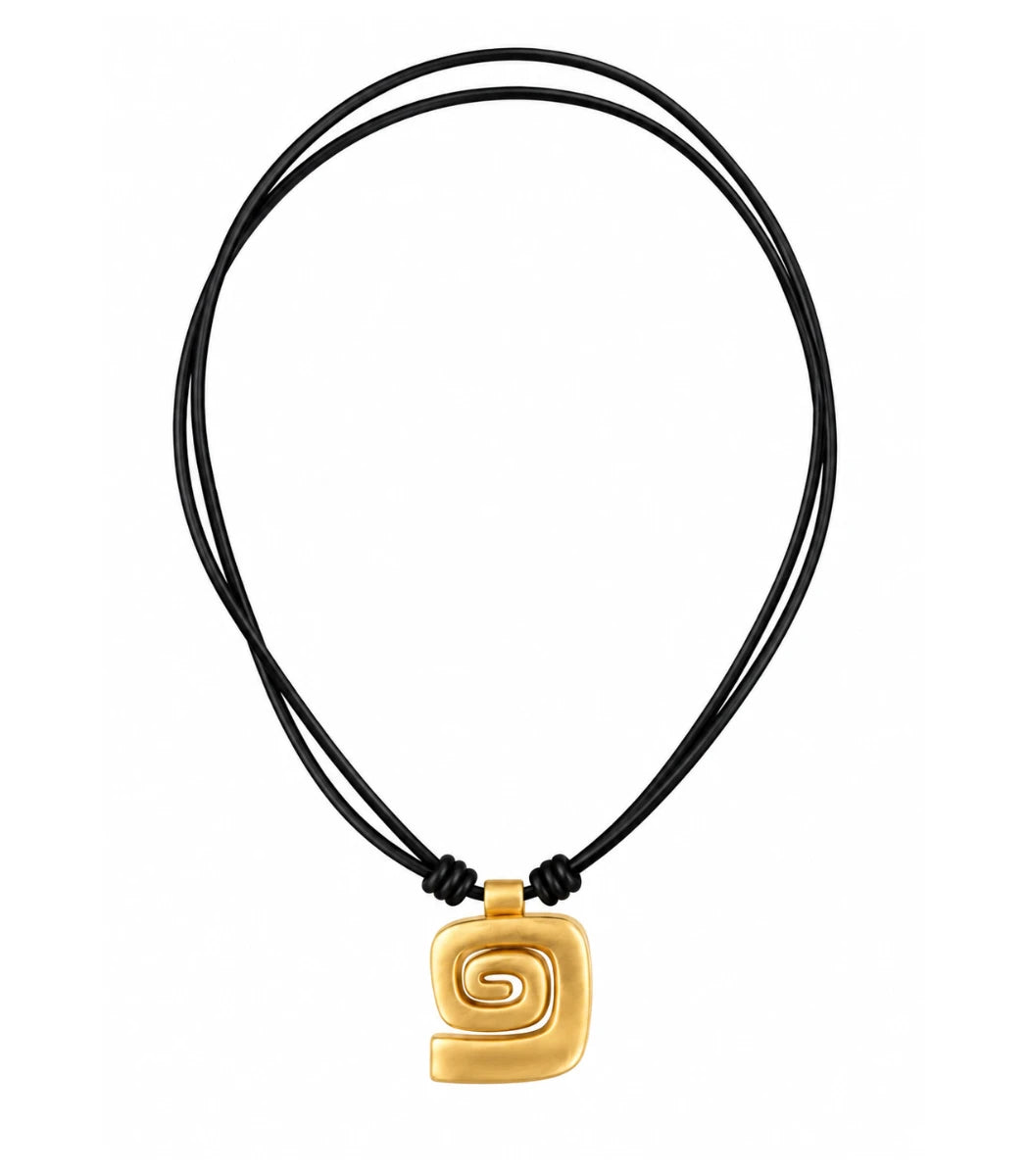 A gold spiral pendant necklace on a black multi-strand cord, shown against a plain white background.