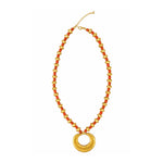 A gold-tone beaded necklace featuring alternating red and gold beads, with a large flat circular gold pendant at the center, displayed on a clean white background.