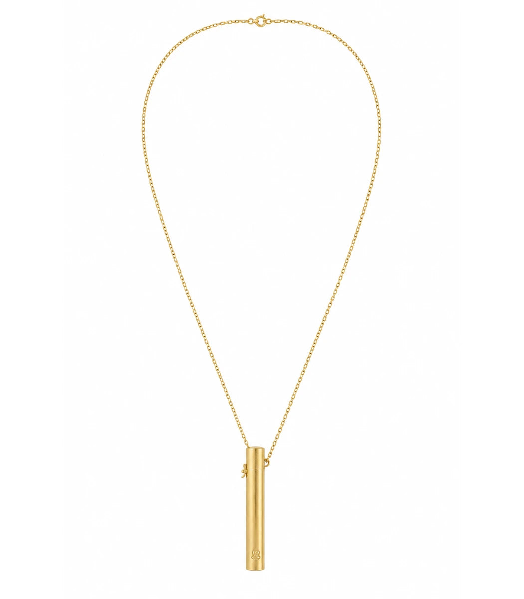 A gold necklace featuring a delicate chain and a vertical cylindrical pendant with a small engraved letter 'A' at the bottom, displayed on a solid white background.